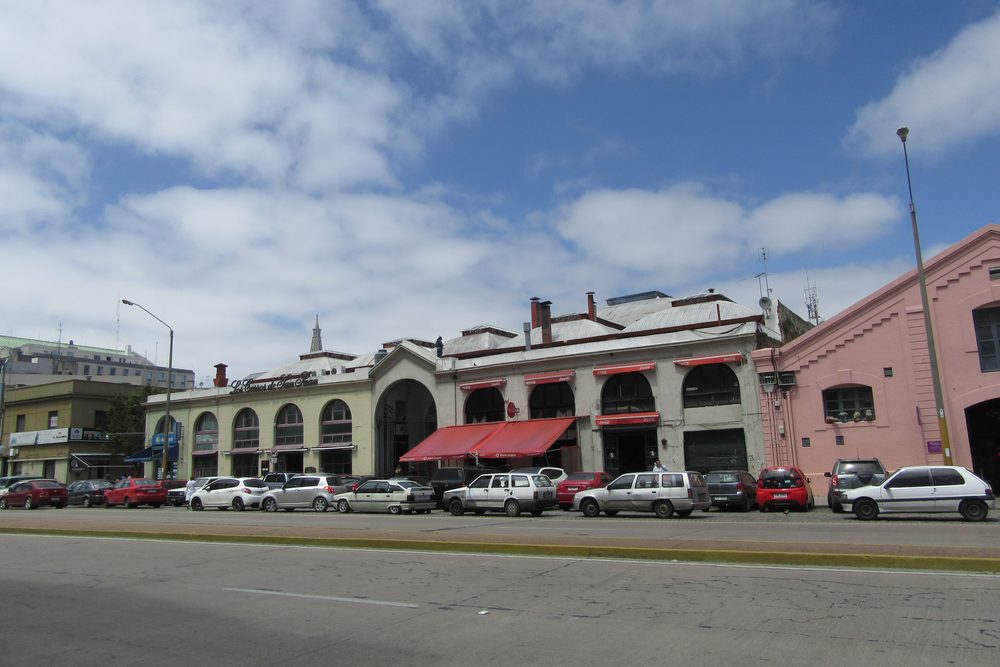 La fachada del Mercado del Puerto de Montevideo desde la calle, con sus arcos de medio punto y el techo a dos aguas