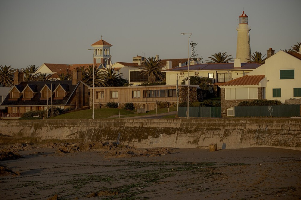 El faro de Punta del Este sobre las casas del puerto, al atardecer