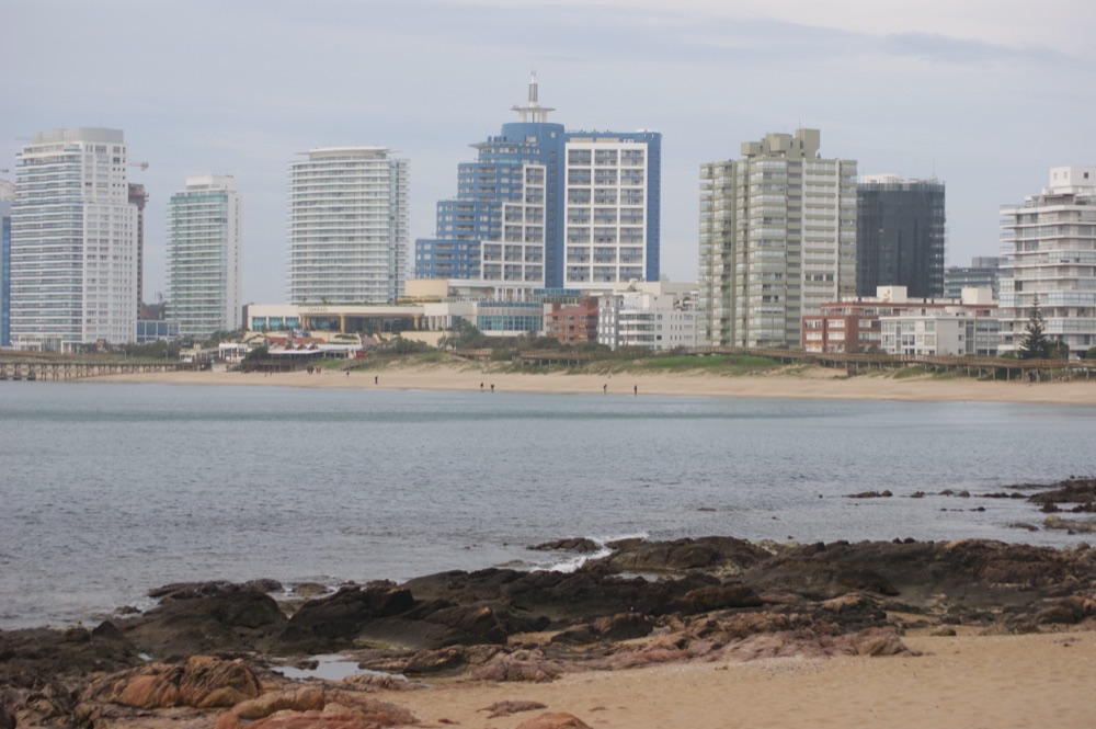 La orilla de la Playa Mansa al caer la tarde, con las torres de la rambla Williman al fondo